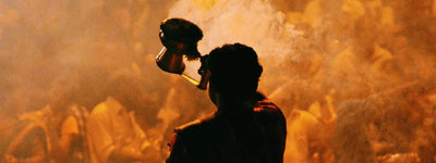 A person carefully lighting sambrani incense on a charcoal tablet 